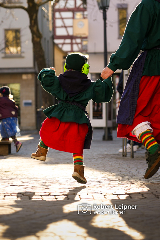 Kind als Riedhutzel hüpft fröhlich bei der schwäbisch-allemannischen Fasnet der Dorauszunft in Bad Saulgau