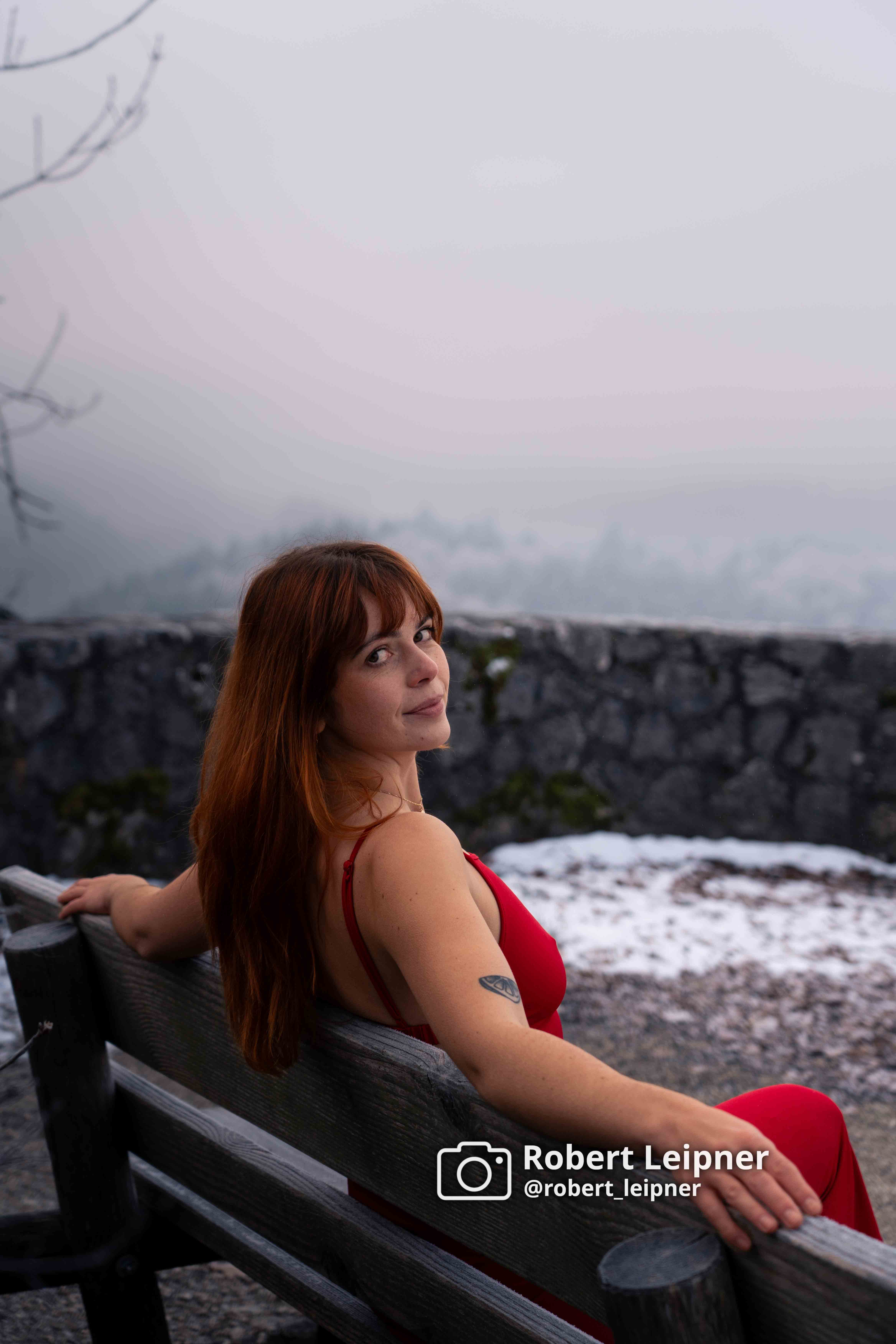 Model in rotem Kleid auf einer Bank