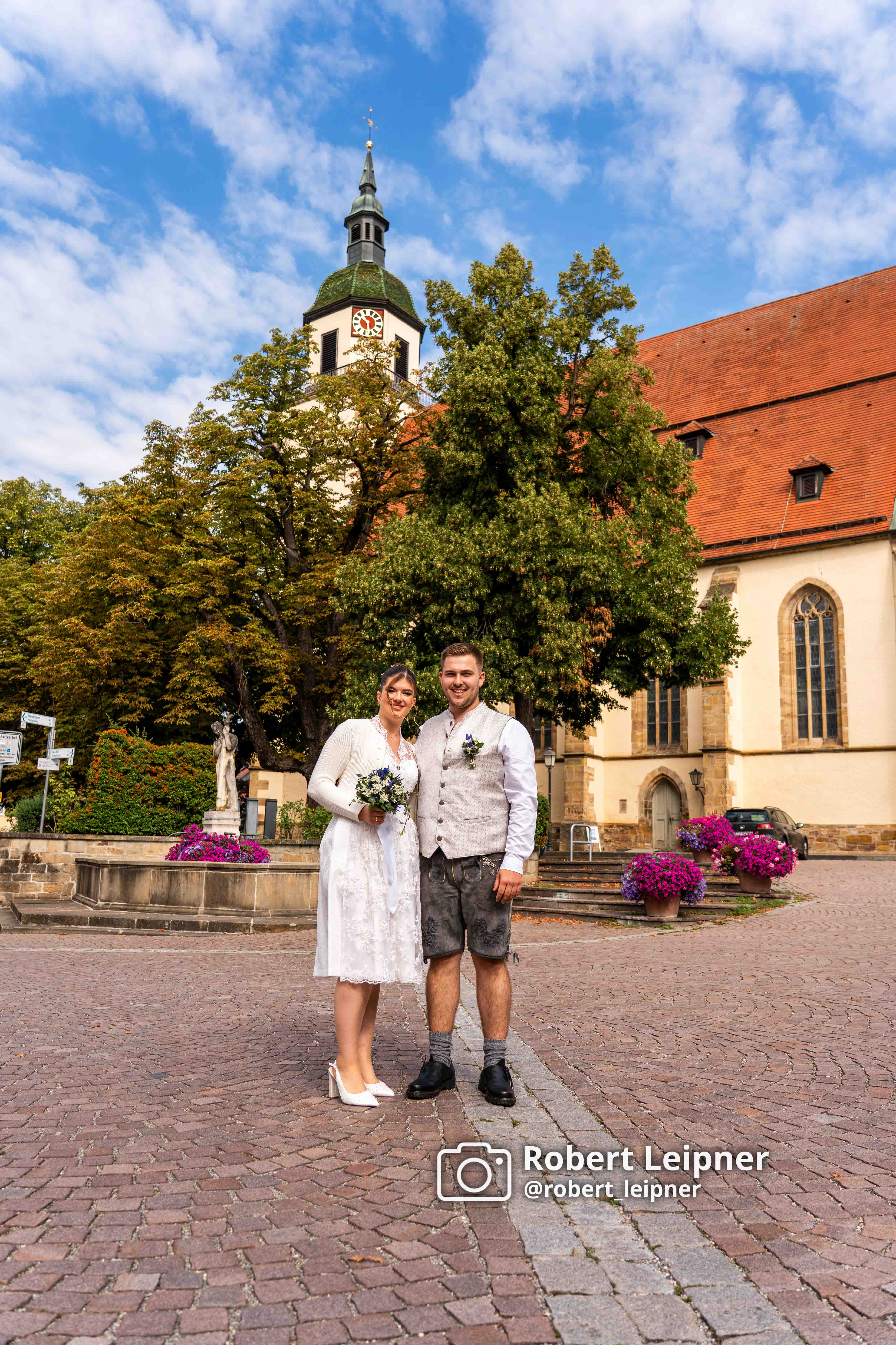 Hochzeitspaar im Sommer vor der Kirche in Weilheim